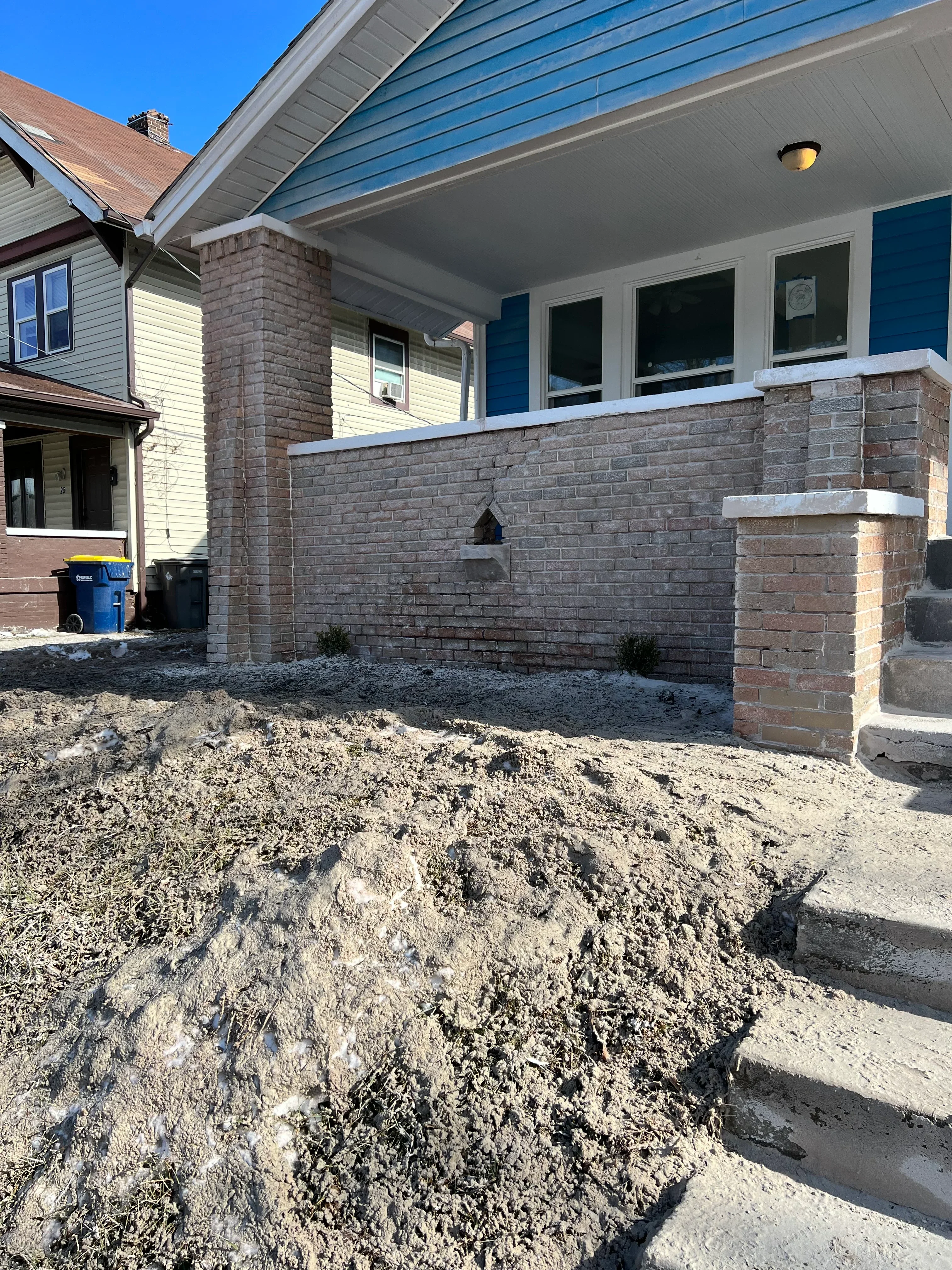 Brick facade after sandblasting restoration, clean masonry surface with white trim and metal roofing