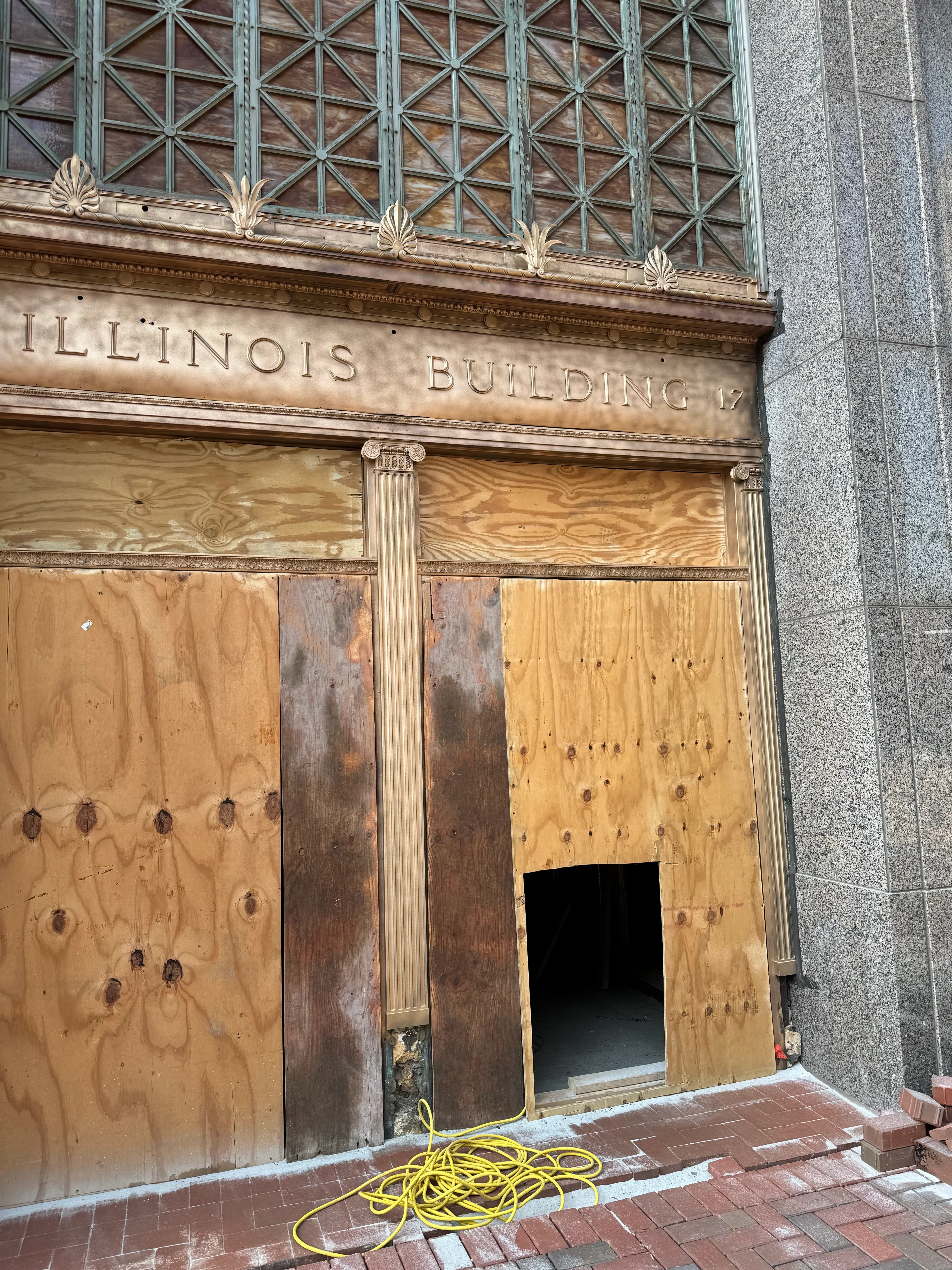 Historic building facade with ornamental stone details and cast iron elements during sandblasting restoration