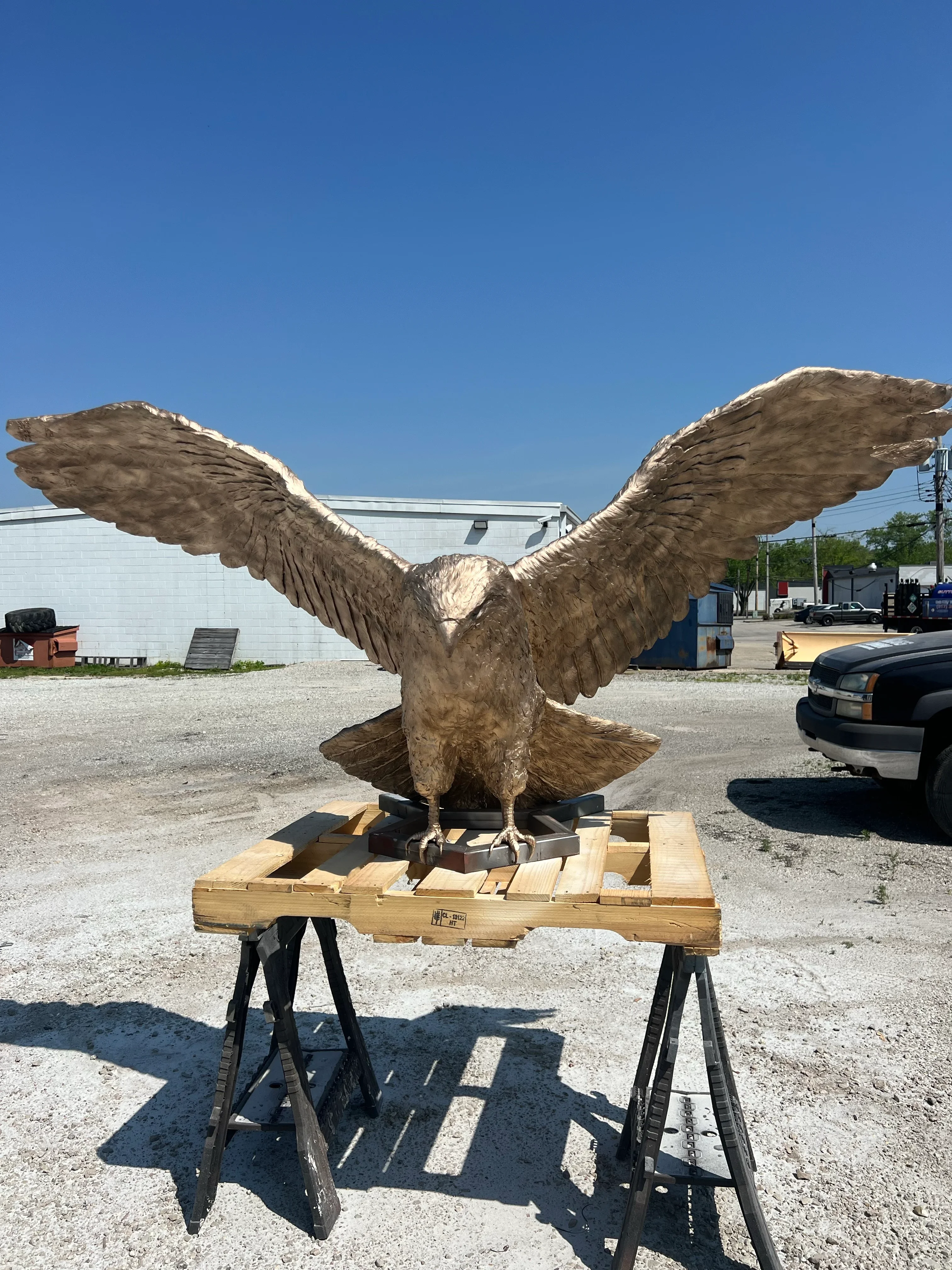 Wooden eagle sculpture with spread wings after sandblasting restoration, mounted on wooden base