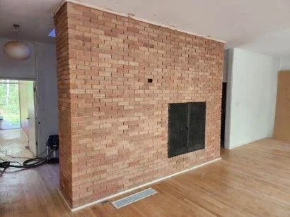 Sandblasted brick fireplace interior with exposed masonry and black firebox opening