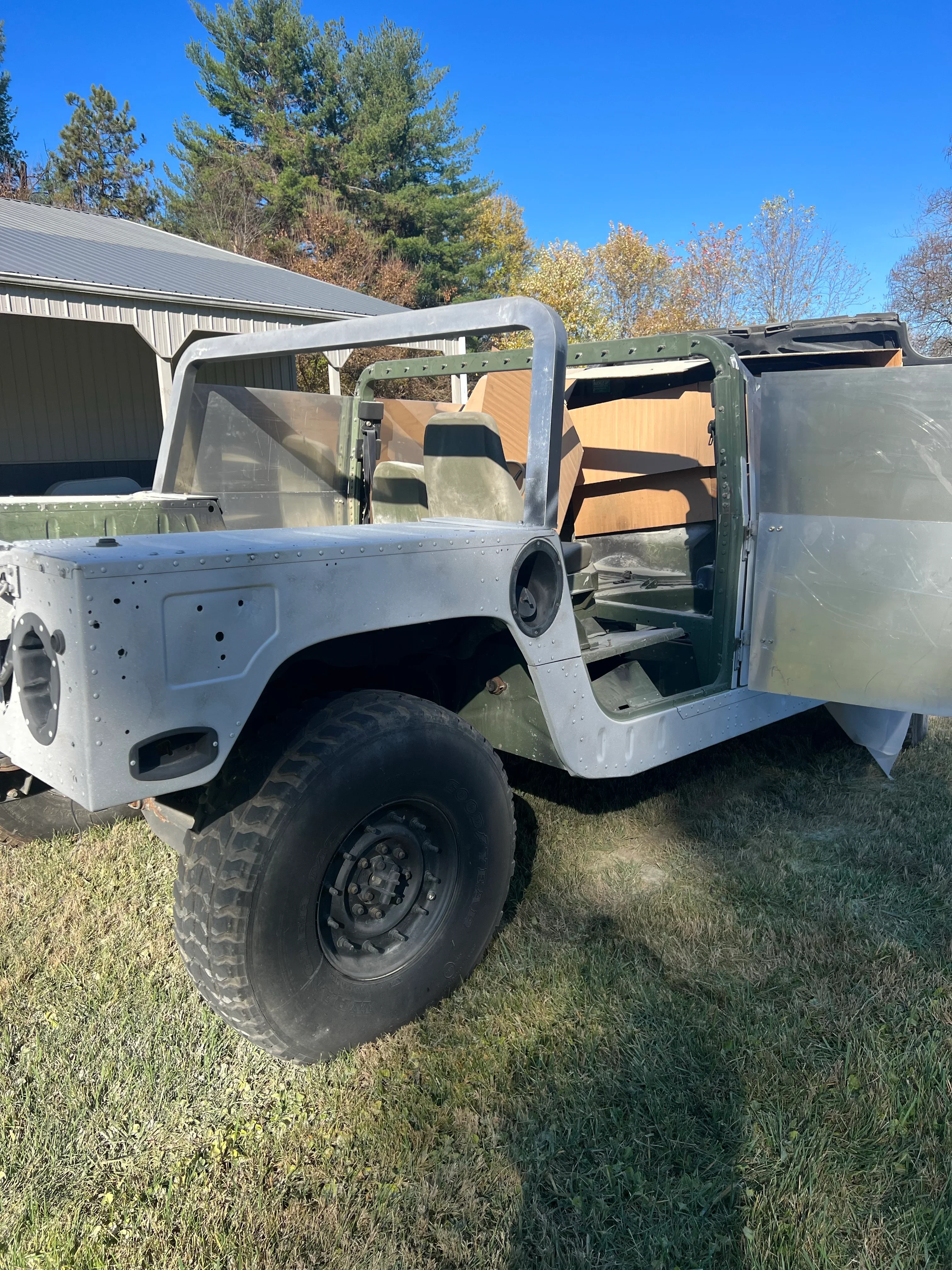 Sandblasted truck bed and frame with bare metal finish, doors open showing interior preparation