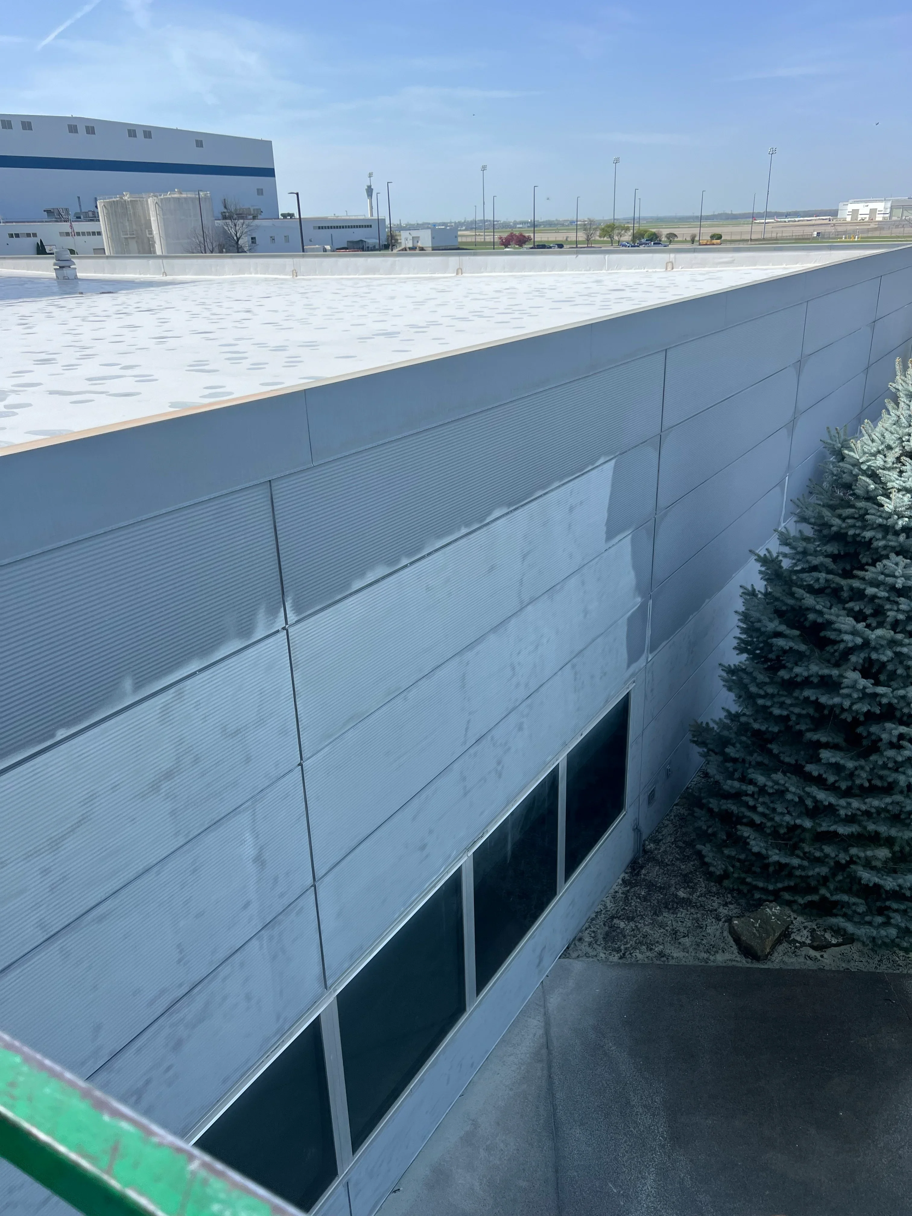 Corrugated metal wall panels and flat roof on industrial building after surface preparation
